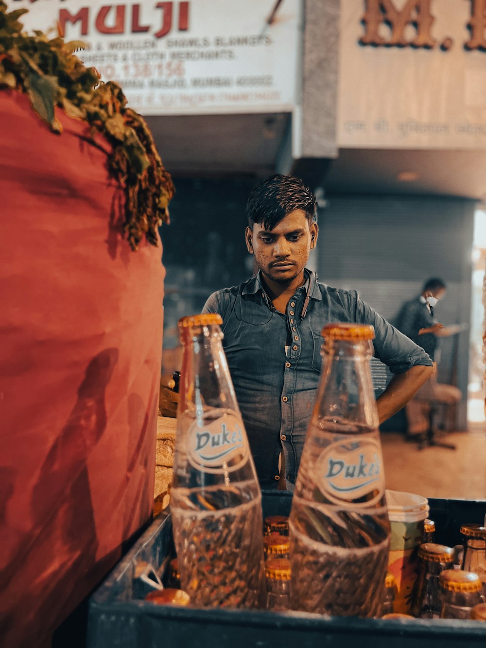a man standing in front of a table filled with bottles