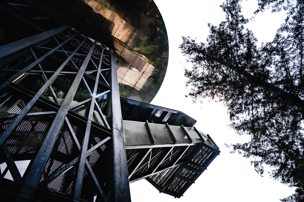 looking up at a tall tower with a mirror on it