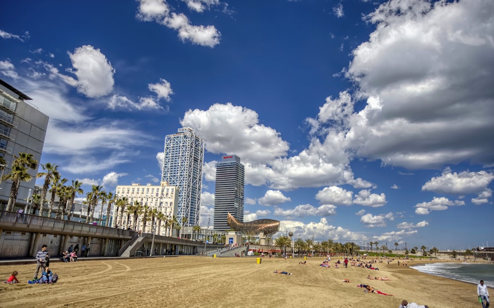 a beach with people on it and buildings in the background