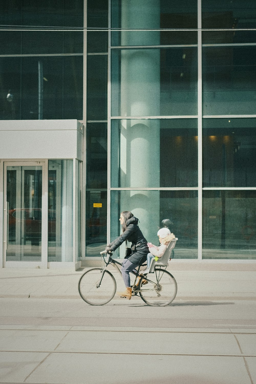 a man riding a bike past a tall building