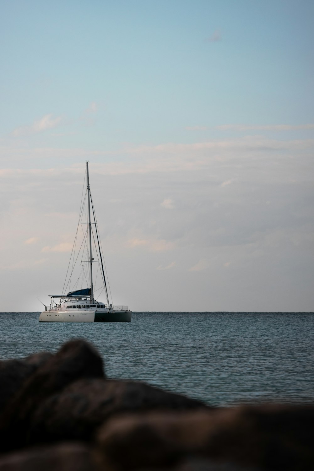 a sailboat floating in the ocean on a sunny day