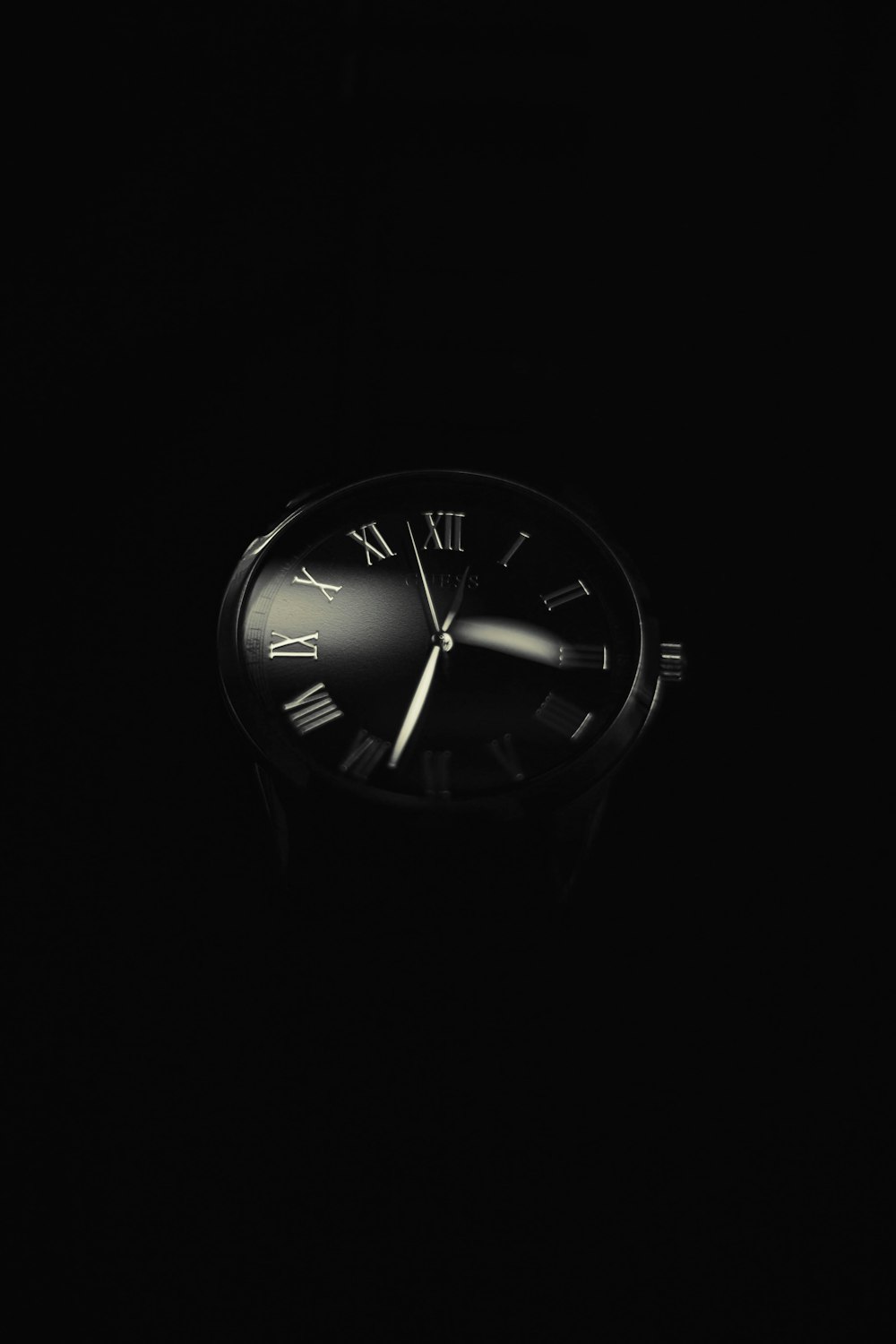 uma foto em preto e branco de um relógio no escuro