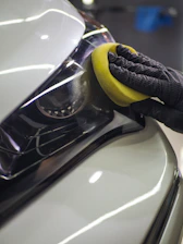 a person with a sponge on a car