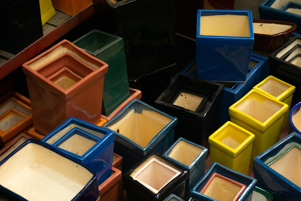 a pile of different colored pots sitting next to each other