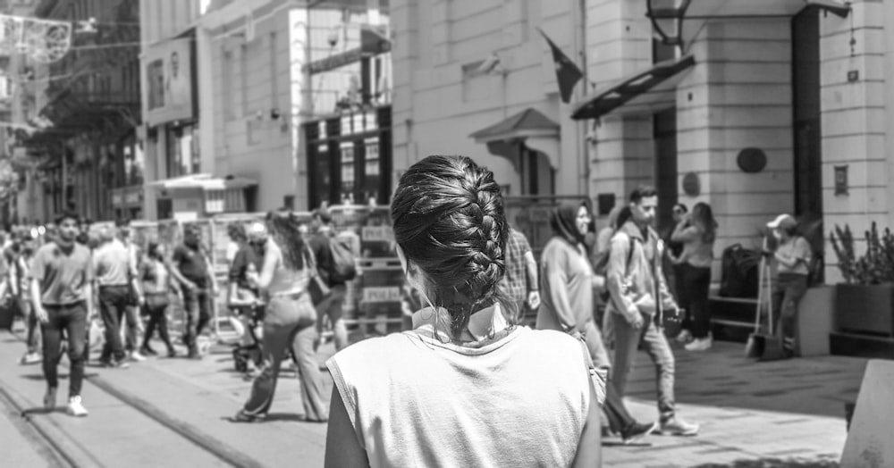 a black and white photo of people walking down a street