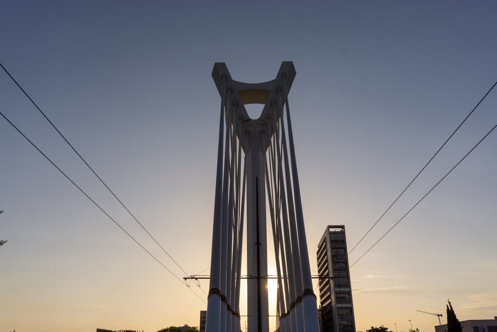 the sun is setting behind a tall tower