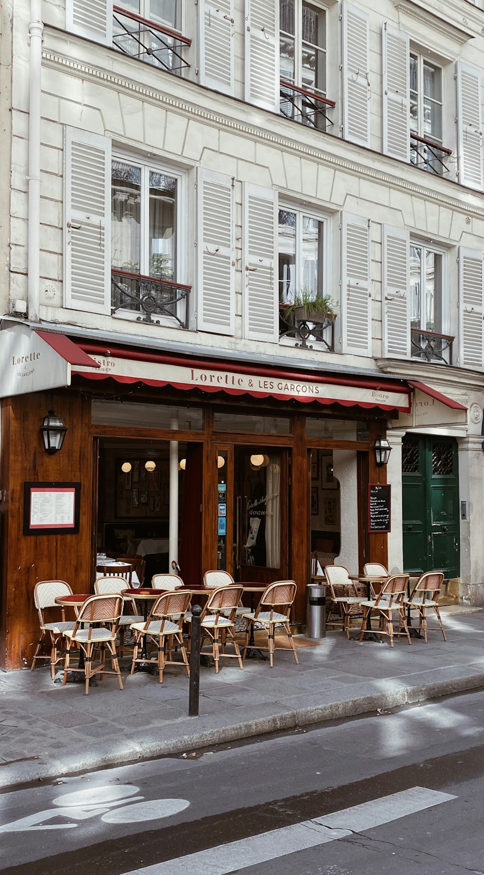 Outdoor bistro tables and chairs on a Paris street corner in the evening