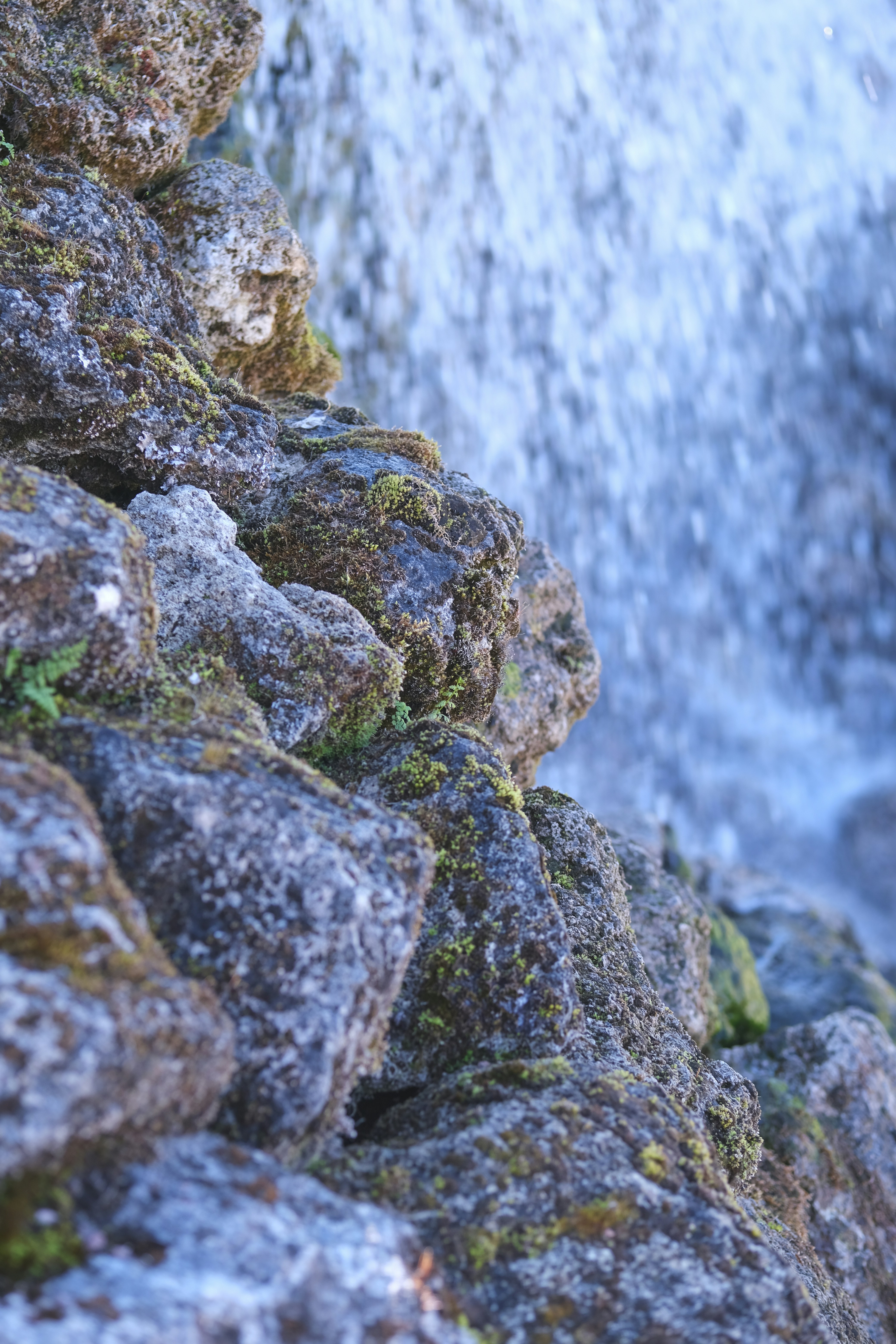 A close up of rocks with a waterfall in the background photo – Free ...