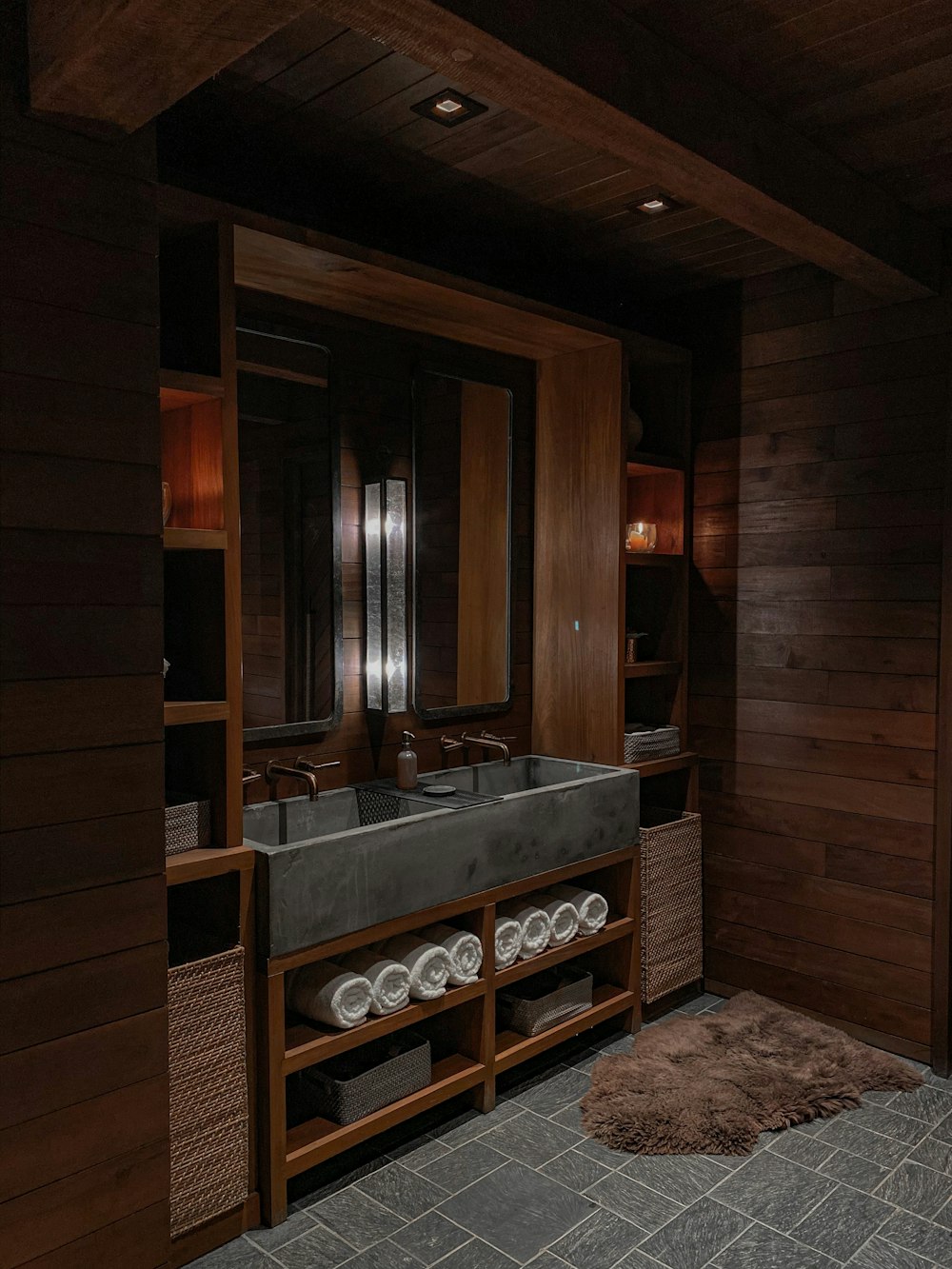a bathroom with a large sink and wooden walls