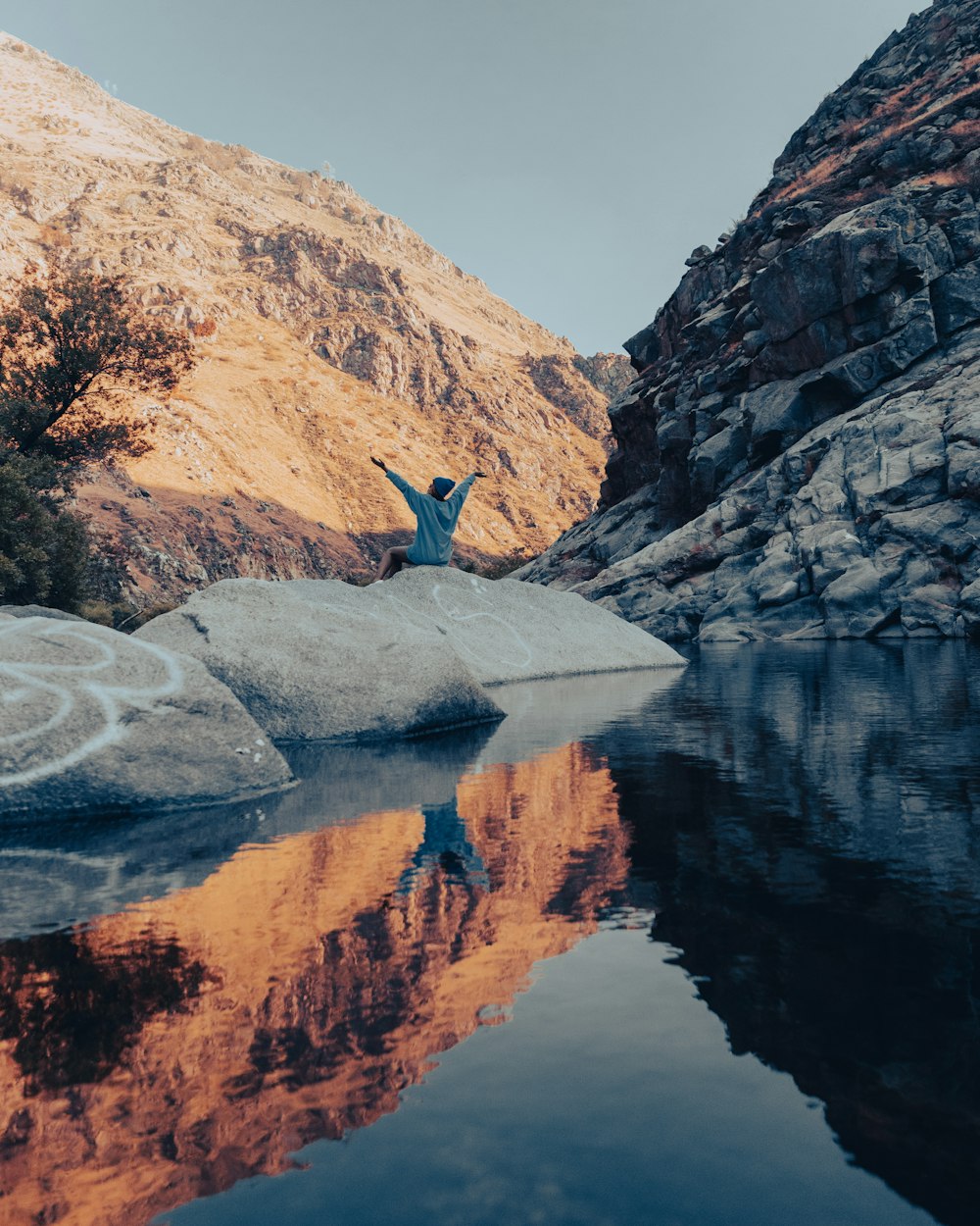 a person standing on a rock near a body of water