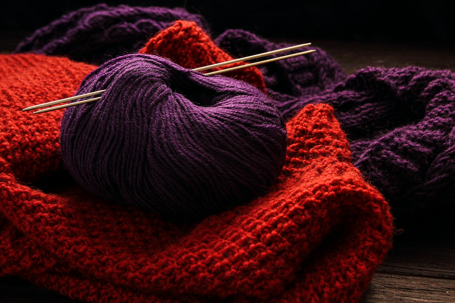 a close up of a ball of yarn and knitting needles