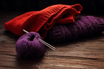 three skeins of yarn and a ball of knitting needles