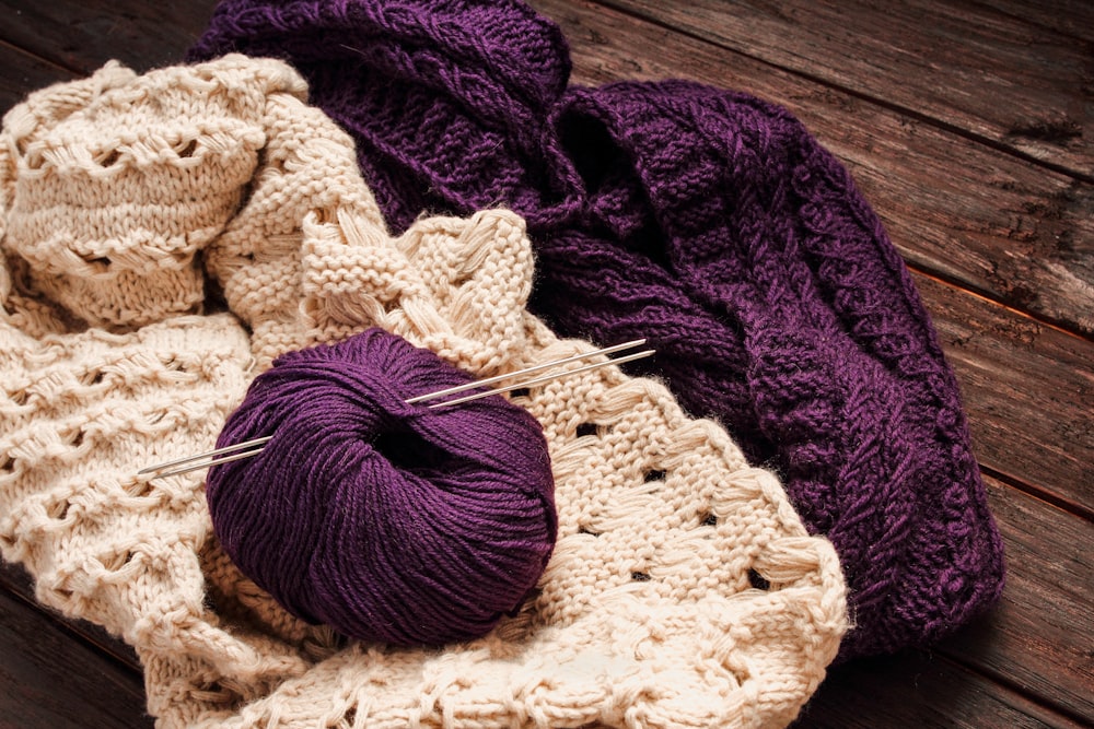 a purple ball of yarn sitting on top of a wooden table