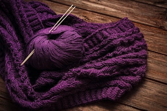 a ball of yarn sitting on top of a purple blanket