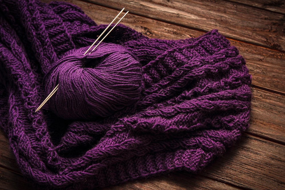 a ball of yarn sitting on top of a purple blanket