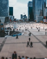 a crowd of people walking around a city square