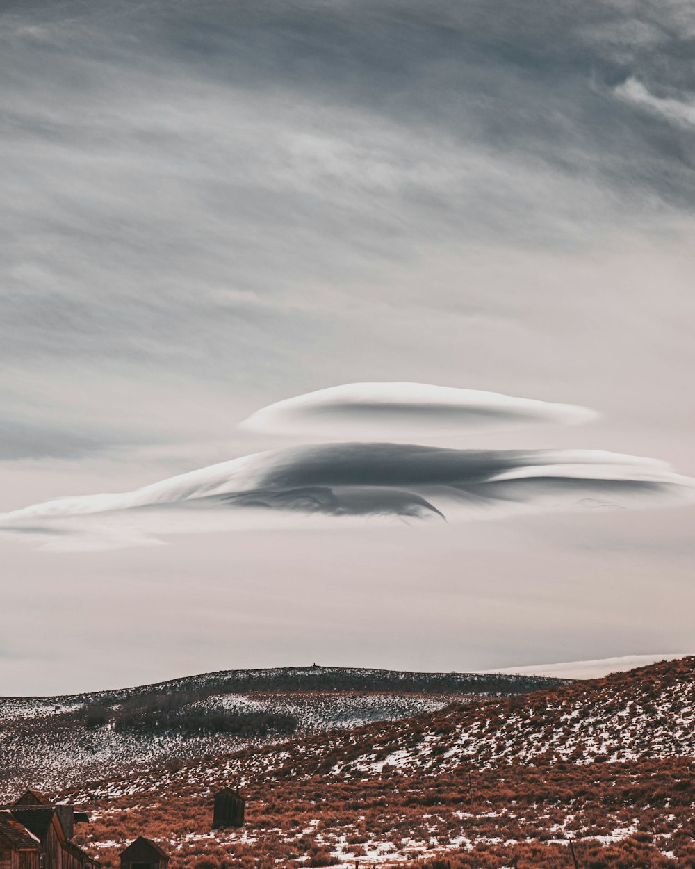 a large cloud is in the sky over a field