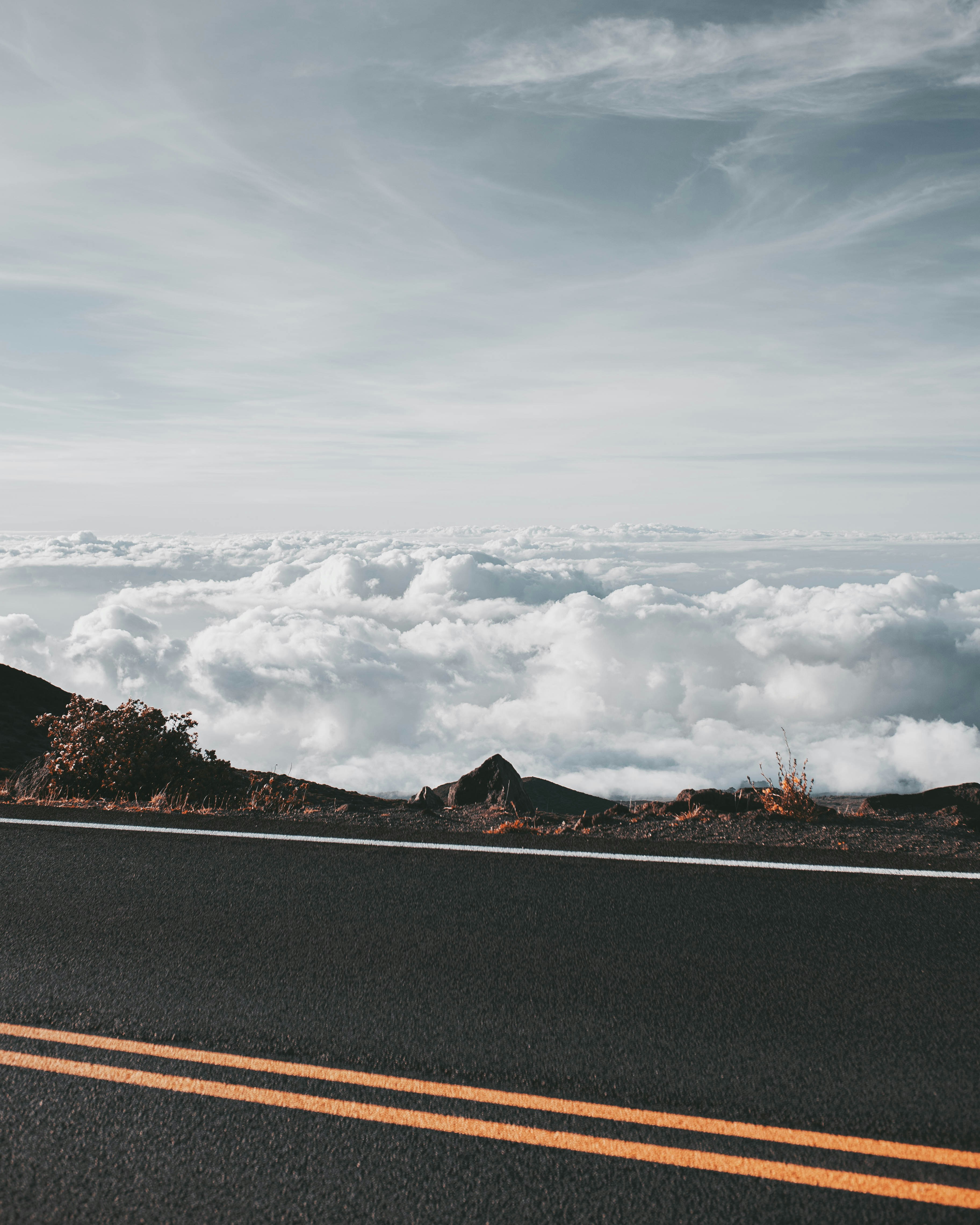 A road with a mountain in the background and clouds in the sky photo ...