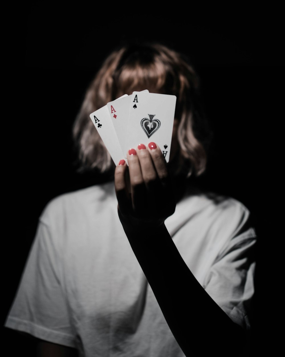 a woman holding two playing cards in her hands