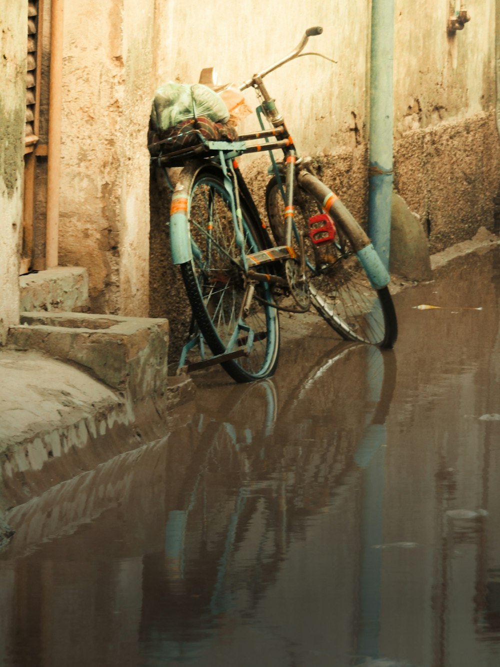 a bicycle parked next to a building on a flooded street