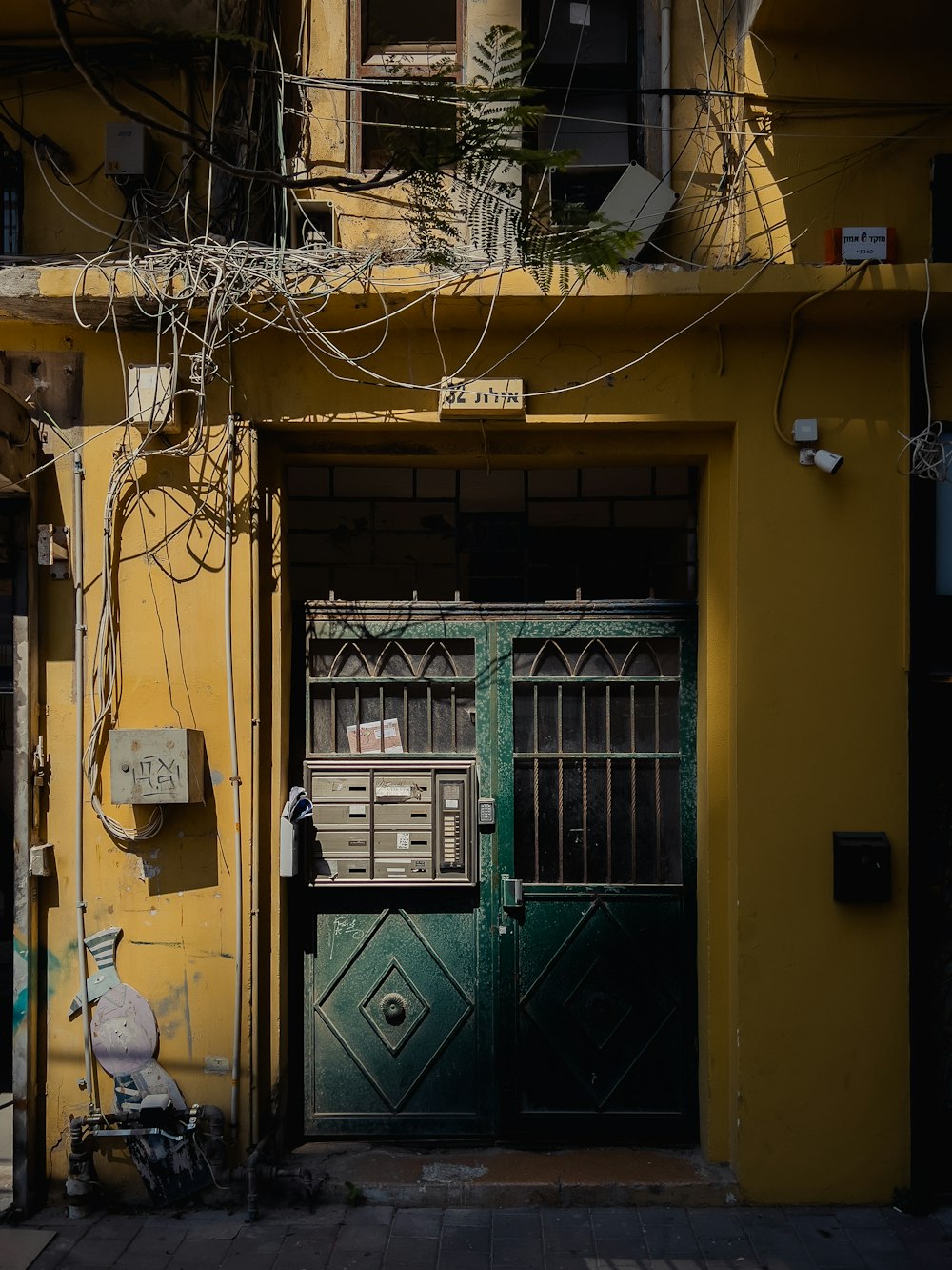 a yellow building with a green door and window