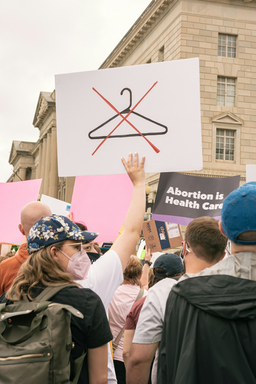 a group of people holding up signs in front of a building