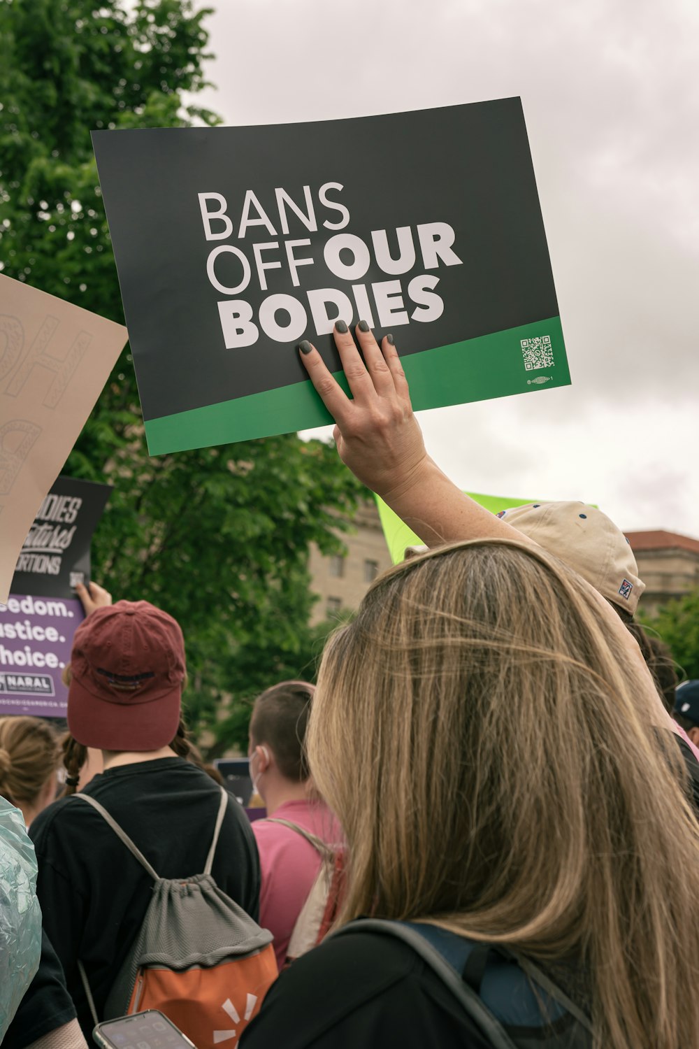 a group of people holding up a sign that says bans off our bodies