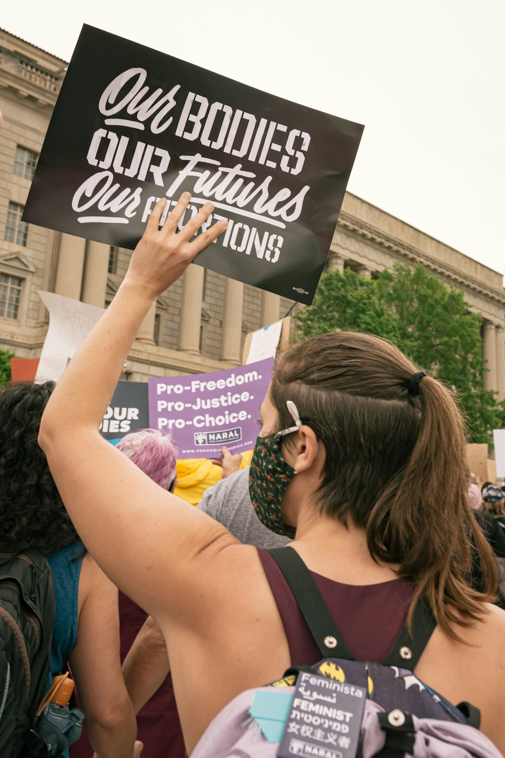 a woman holding up a sign in front of a crowd