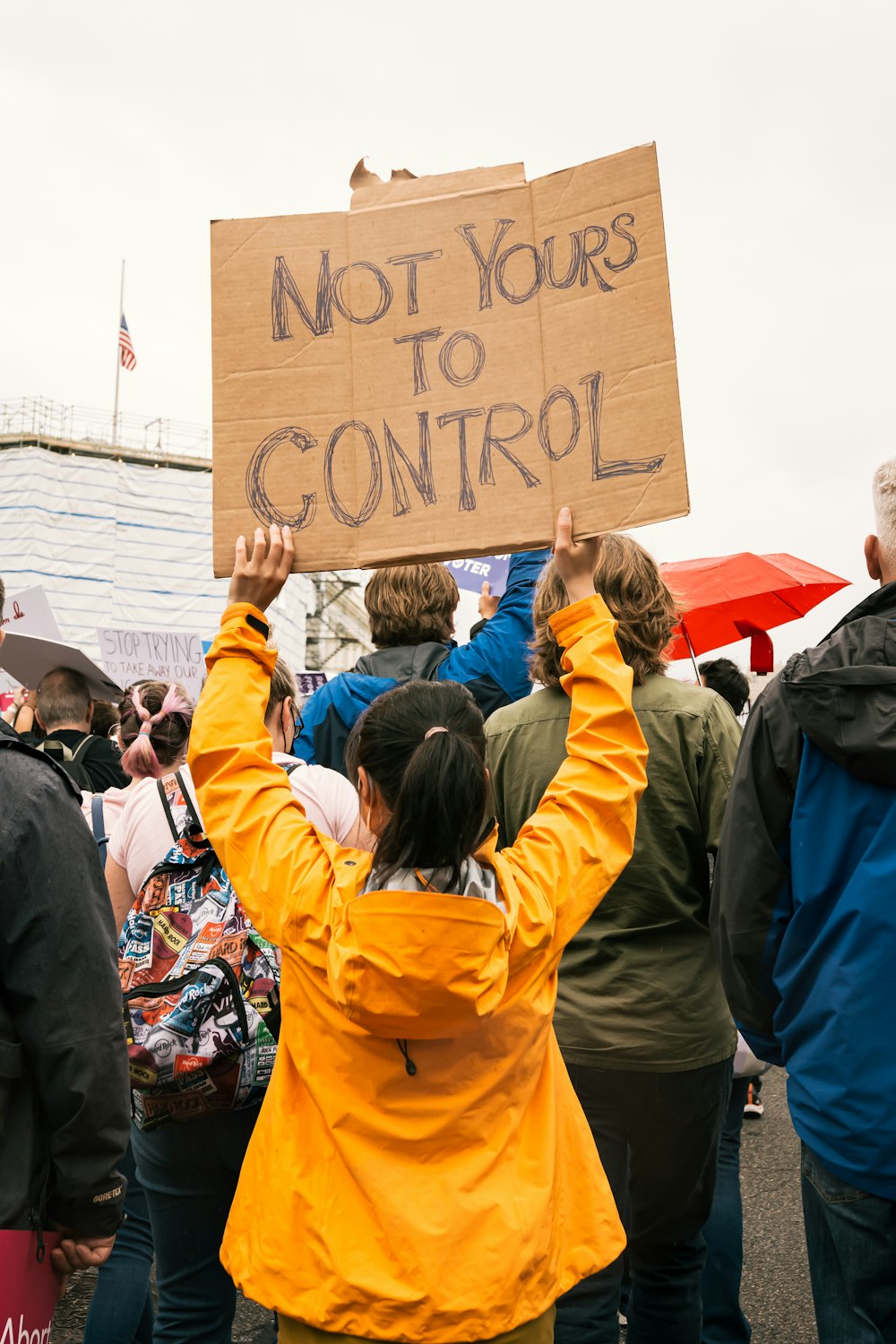 a group of people holding a sign that says not yours to control