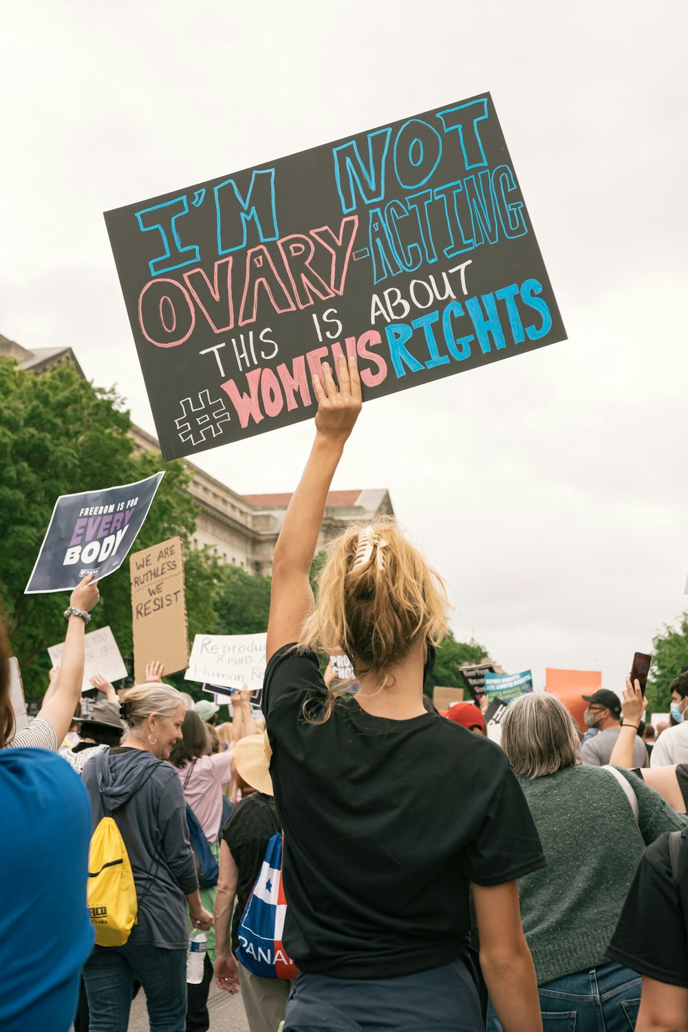 a woman holding up a sign in a crowd