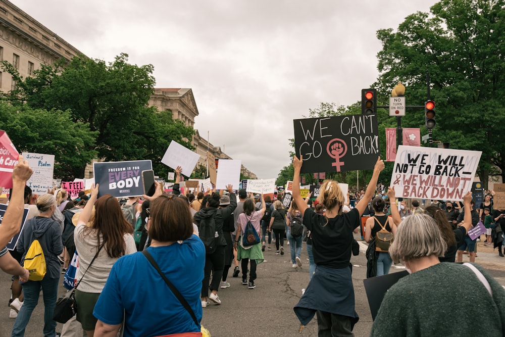 a group of people holding up signs on a street