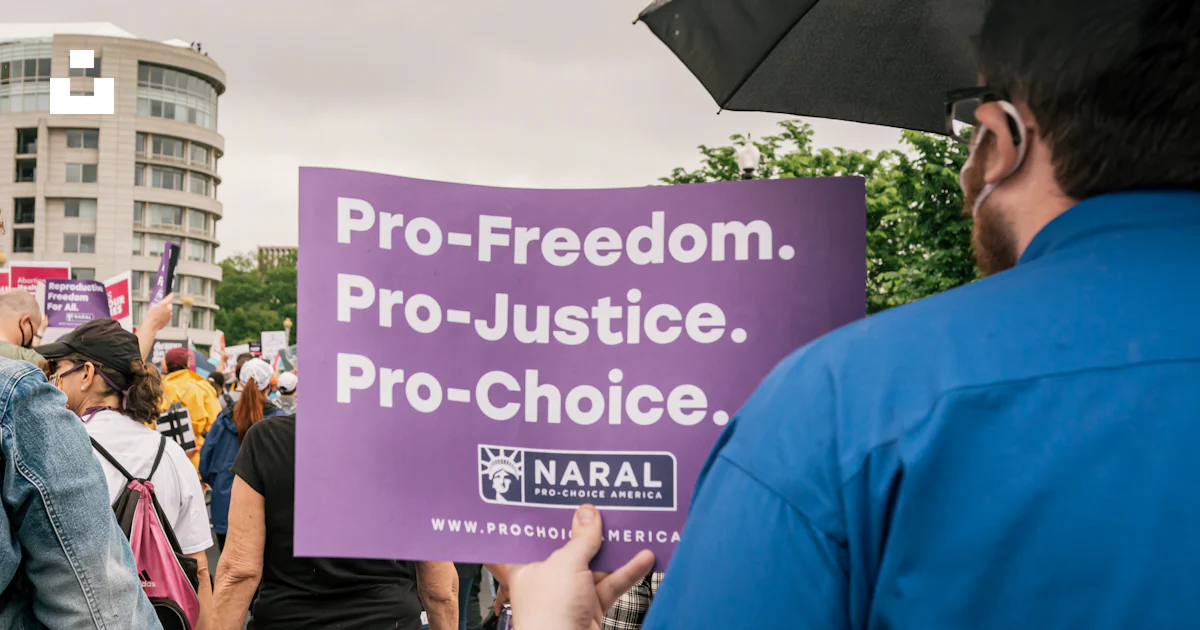 A man holding a sign that reads pro - freedom pro - justice pro ...