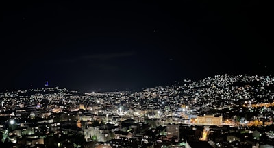A dramatic city skyline at night with lights twinkling.