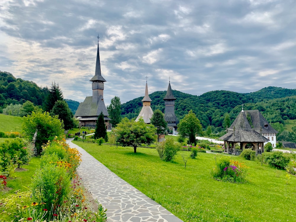 a path leading to a small village with a church in the background