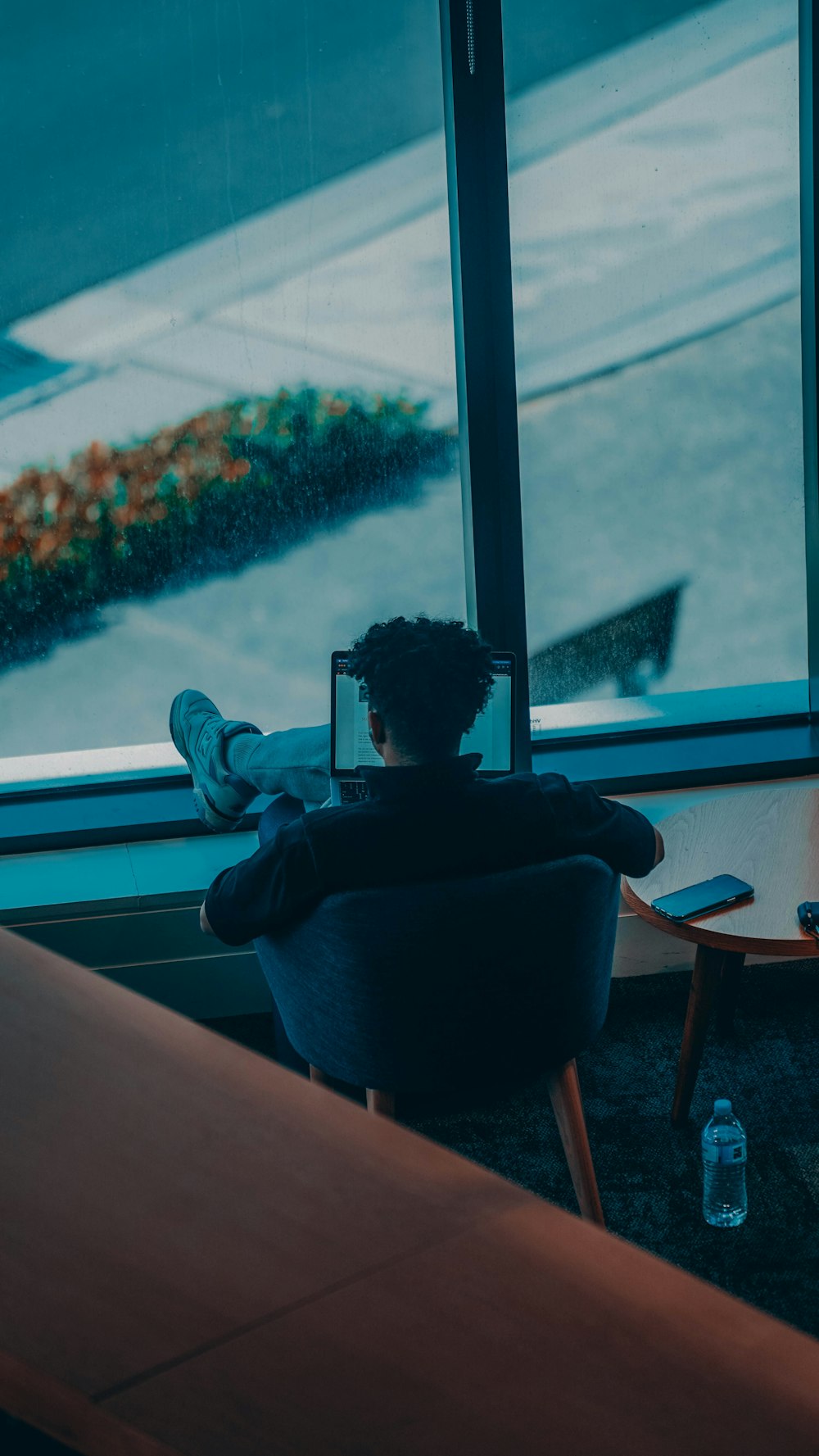 a person sitting in a chair looking out a window