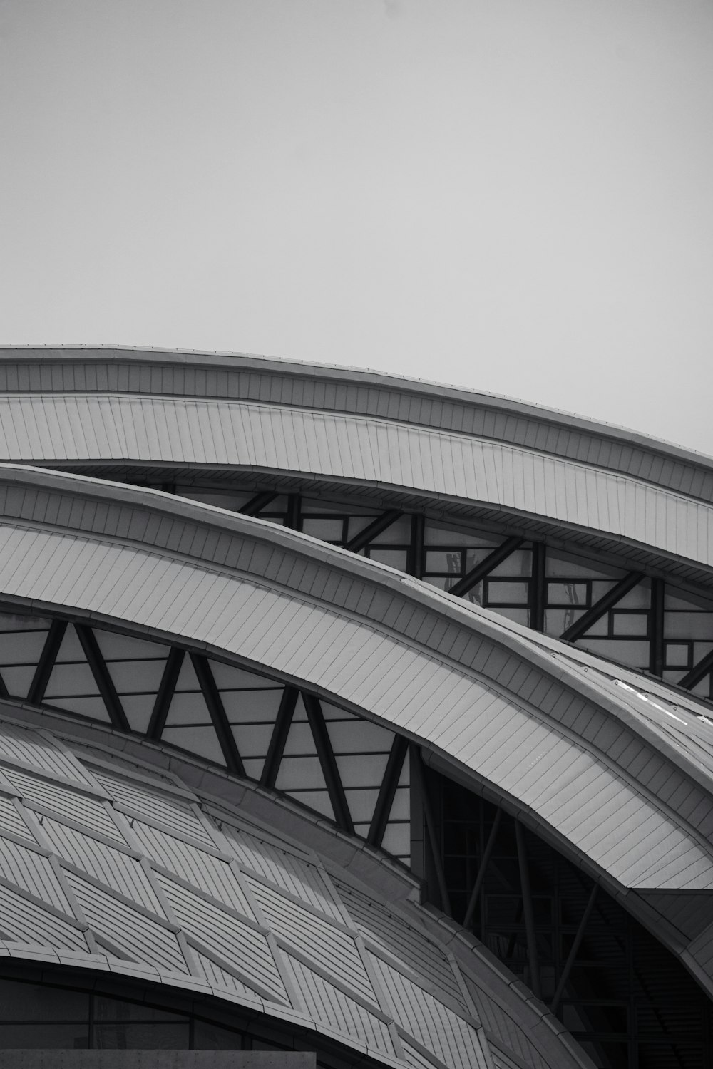 a black and white photo of an airplane flying over a building