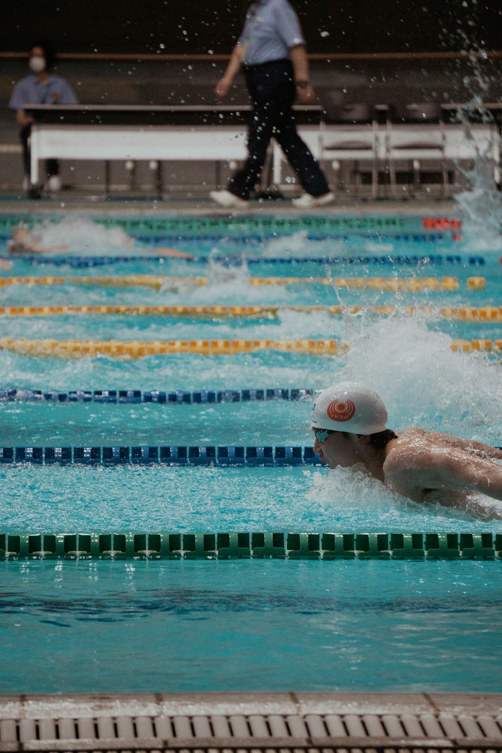 Un homme nageant dans une piscine avec un chapeau