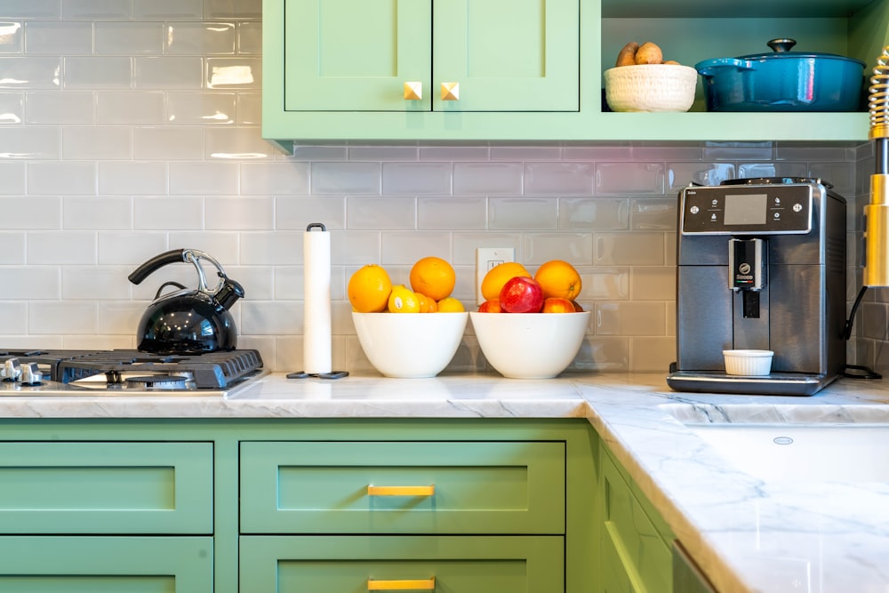 a kitchen with green cabinets and white counter tops