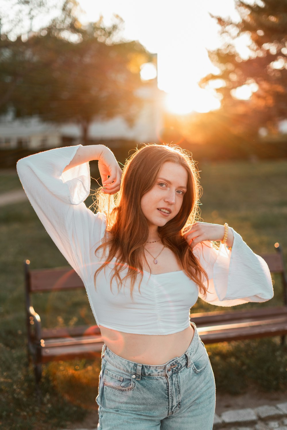 a woman posing for a picture in front of a bench