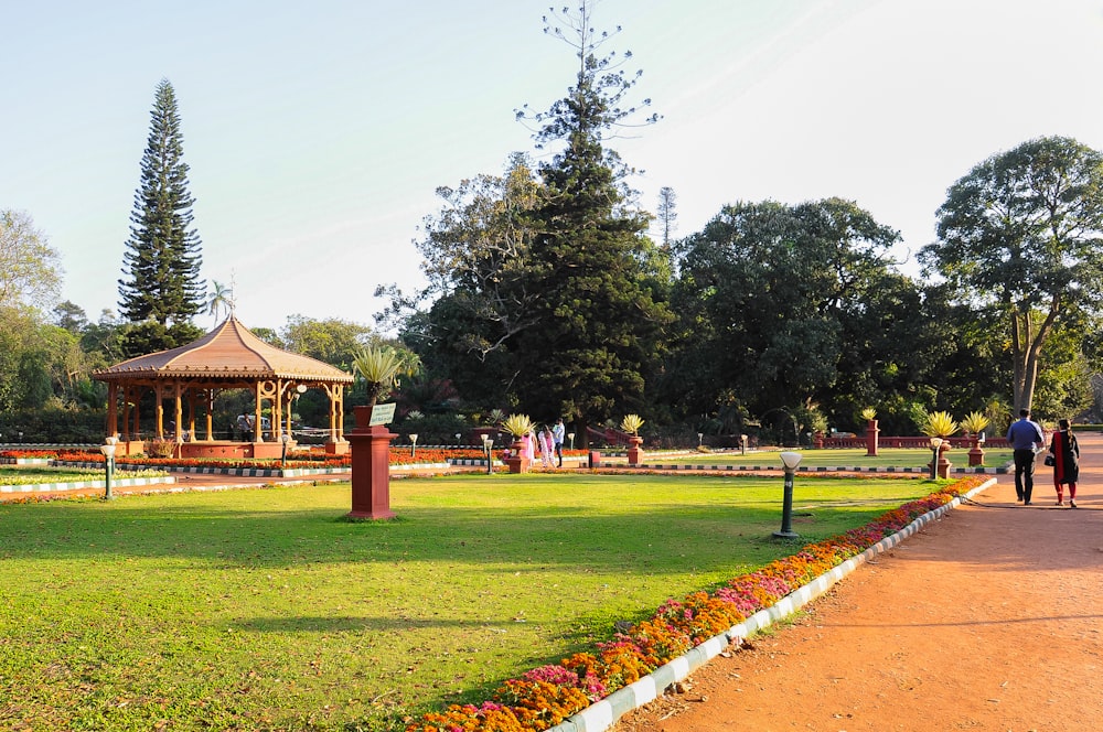 um parque com um gazebo e pessoas andando ao redor