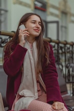a woman sitting on a bench talking on a cell phone