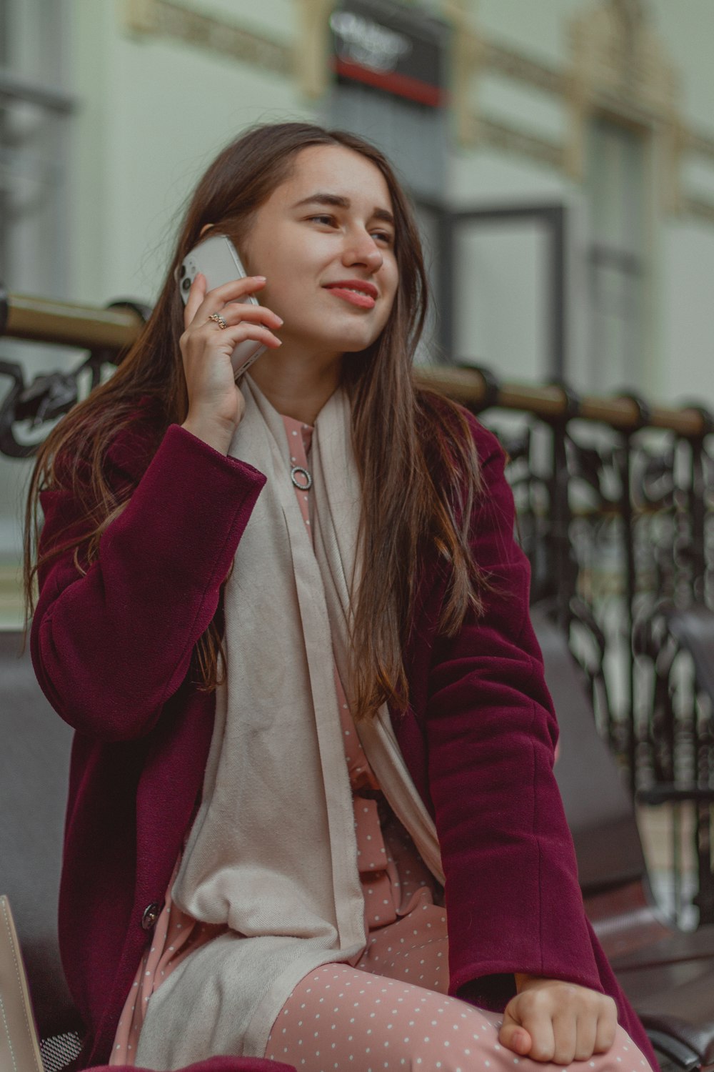 a woman sitting on a bench talking on a cell phone