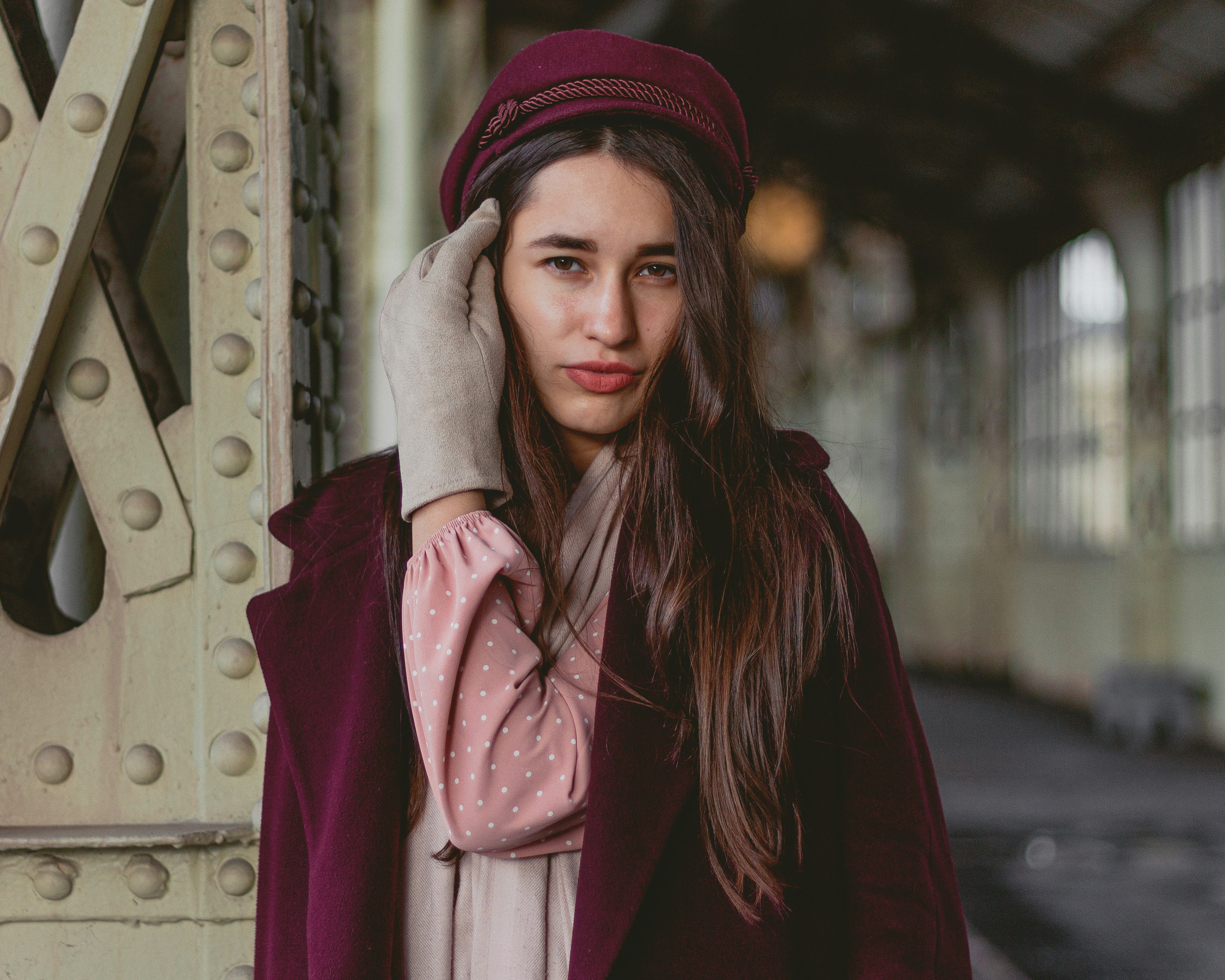 a woman with long hair wearing a burgundy coat