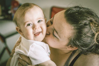 Smiling doctor gently examining a happy infant.