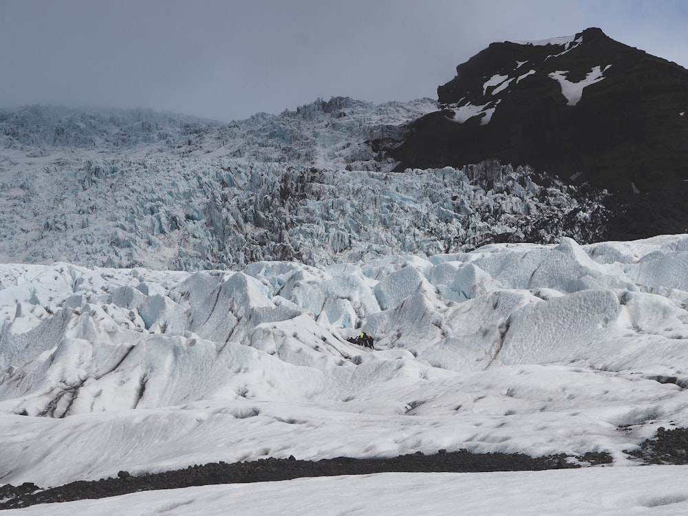 a large glacier with a mountain in the background