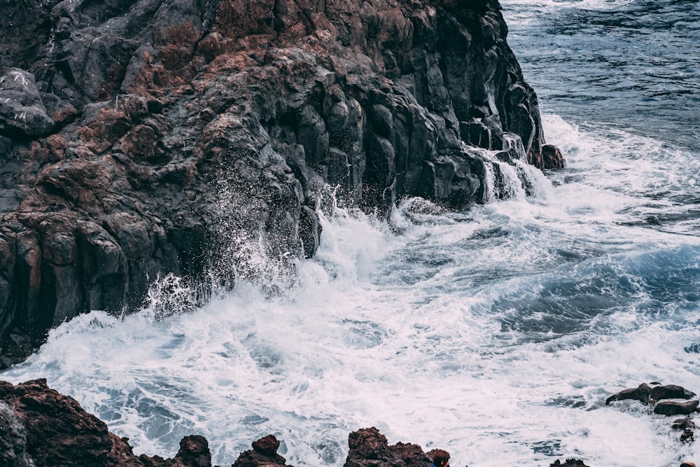 a rocky shore with waves crashing against the rocks