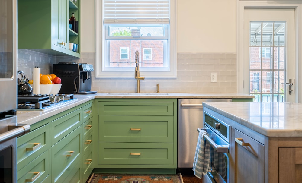 a kitchen with green cabinets and white counter tops