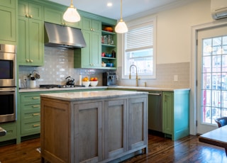 a kitchen with green cabinets and a center island