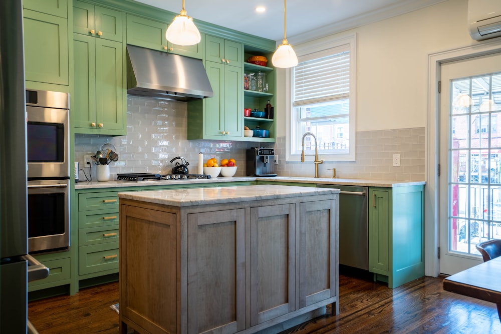 a kitchen with green cabinets and a center island