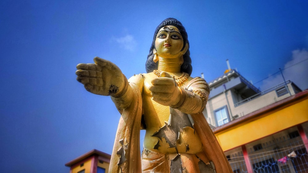 a statue of a woman in a yellow outfit